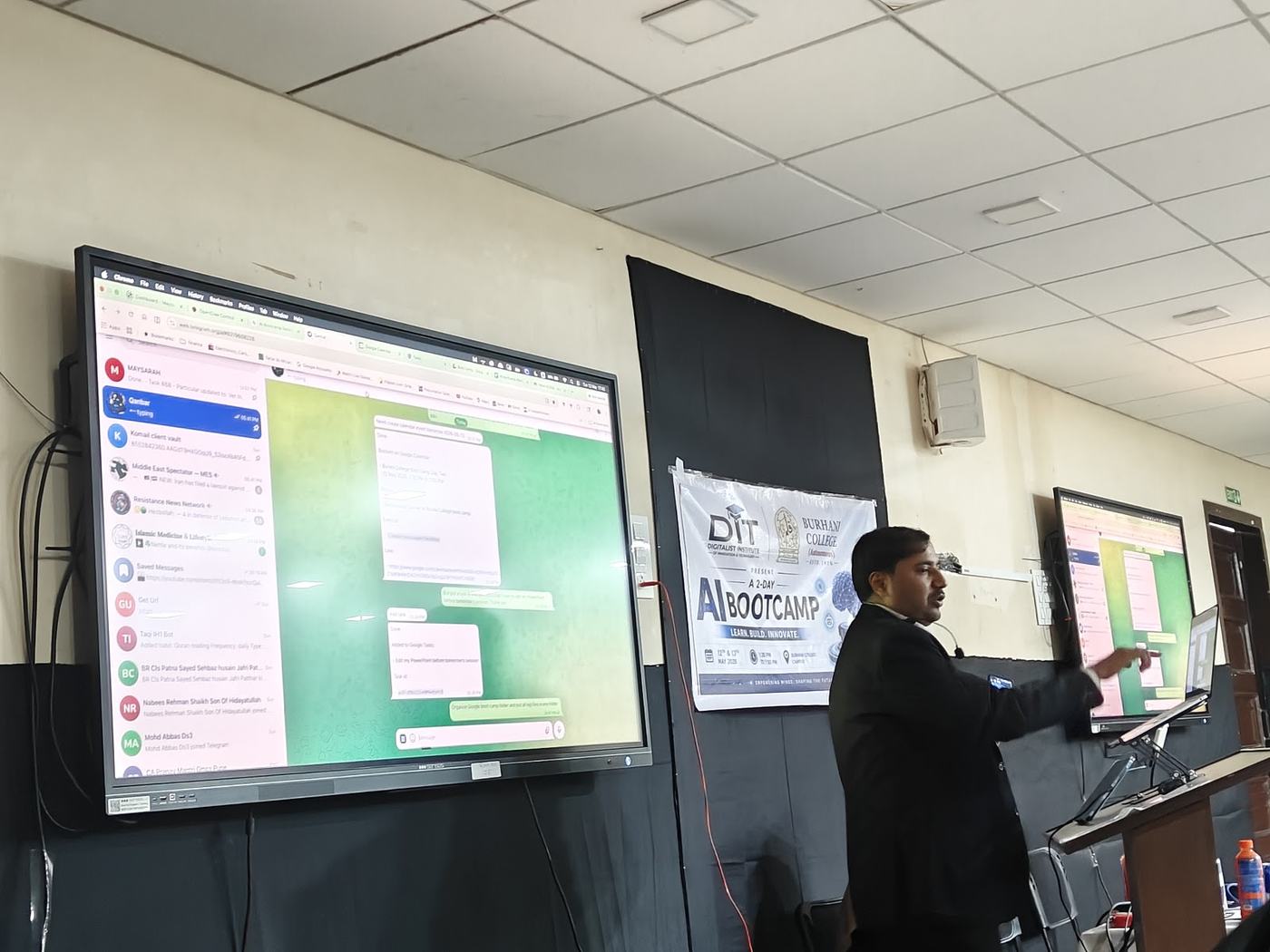 Ali teaching from the big screen beside the DIT AI Bootcamp banner