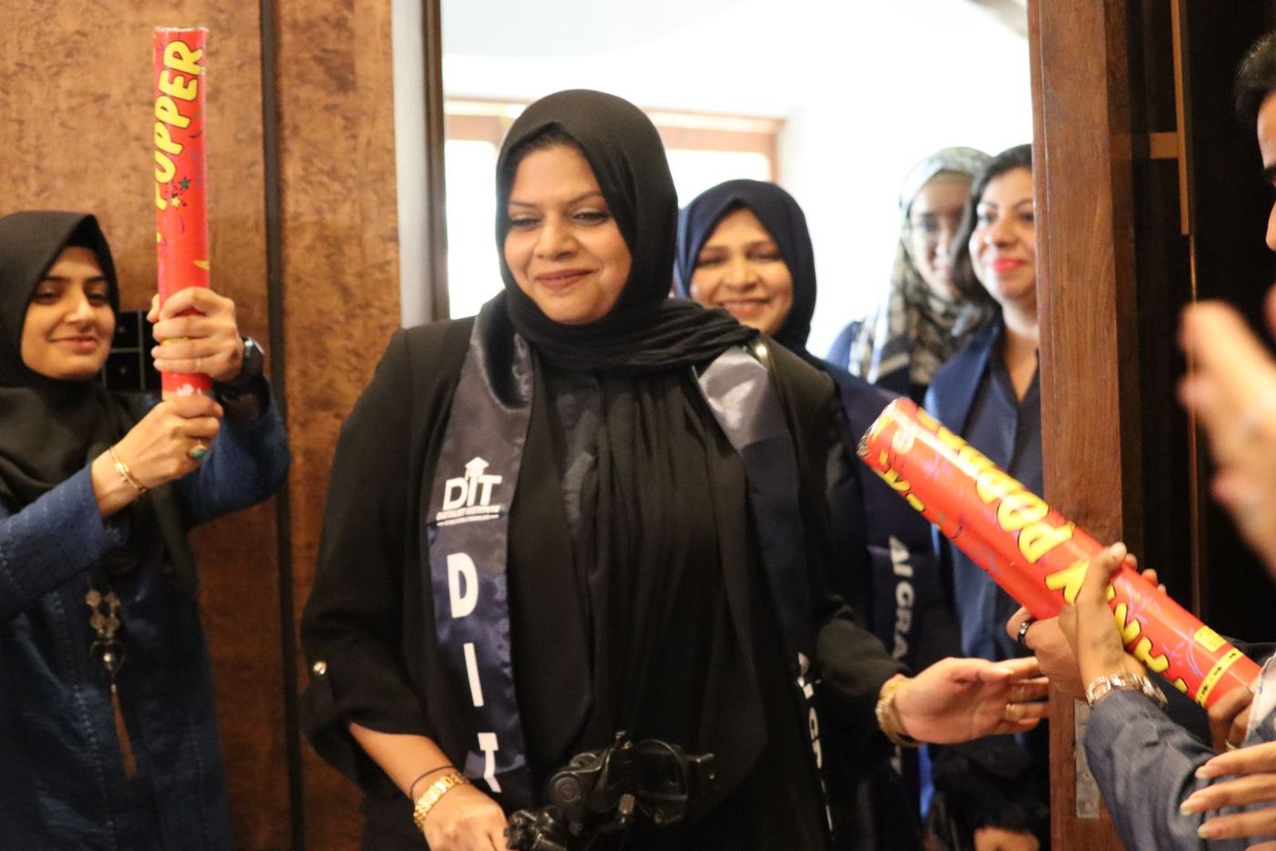 A graduate walks in as confetti cannons fire