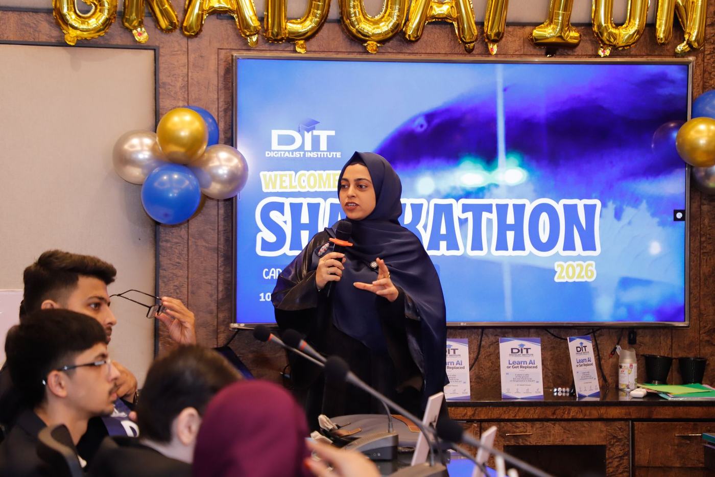 The Sharkathon title on screen as a graduate presents